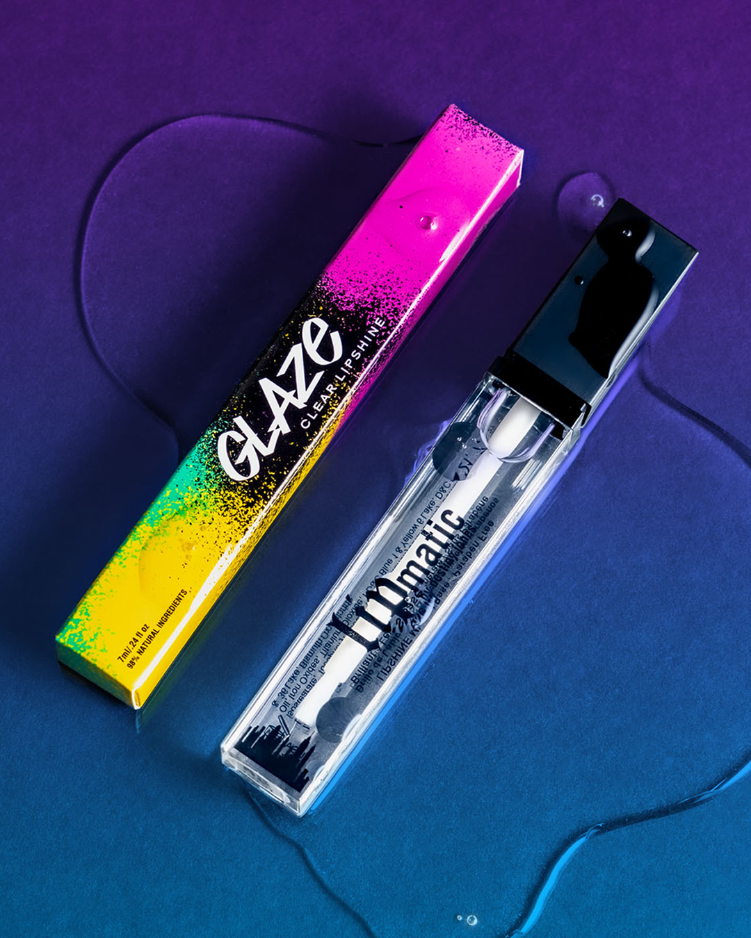 A tube of Glaze LipShine with a colorful lid placed next to it on a blue textured background.